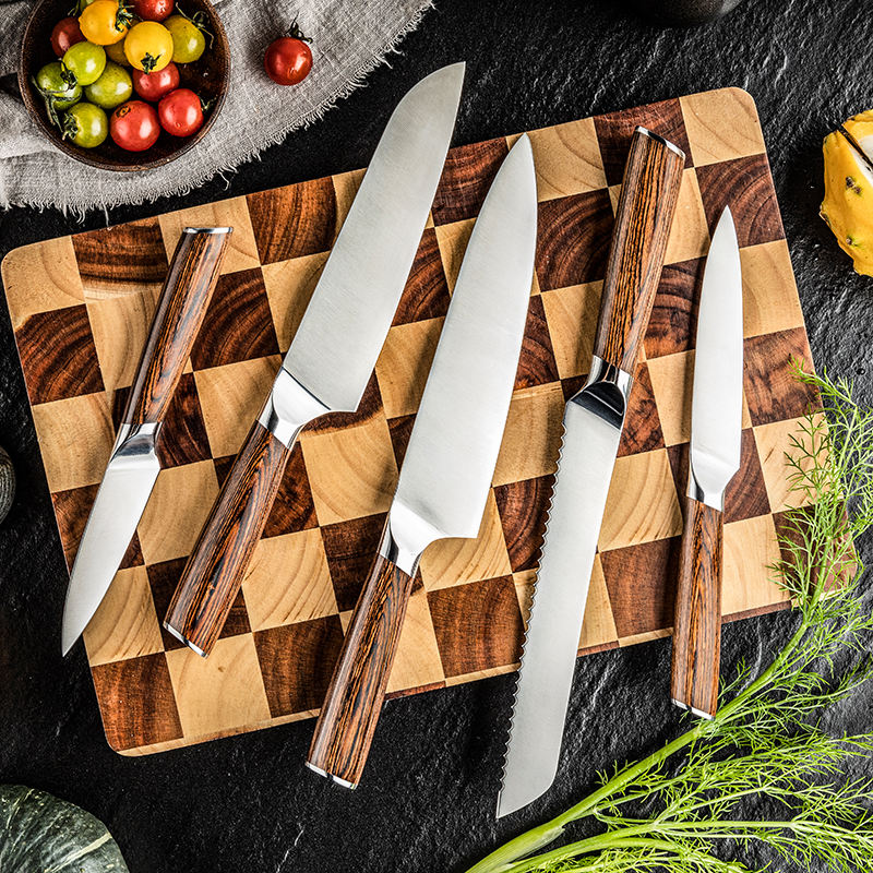 stainless steel kitchen knives flat lay on cutting board
