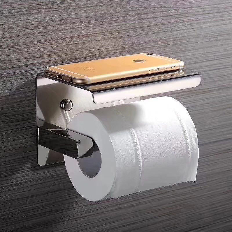 wall mounted stainless steel toilet paper holder in use
